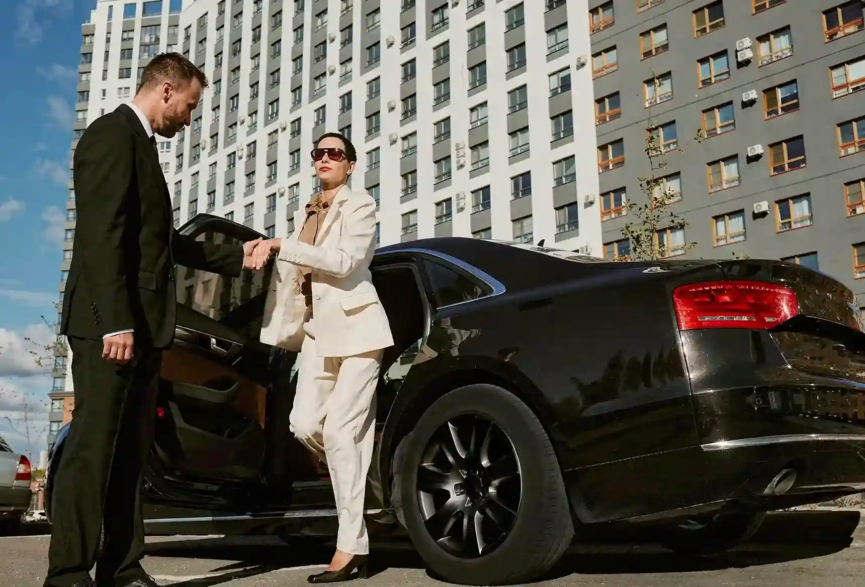 Executive chauffeur opening luxury vehicle